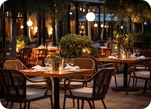 Een openluchtrestaurant met rieten meubels en felle verlichting